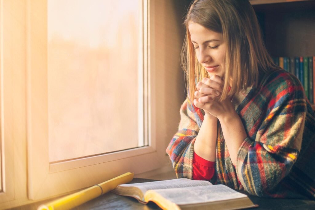 Believer praying with an open Bible to grow in faith.